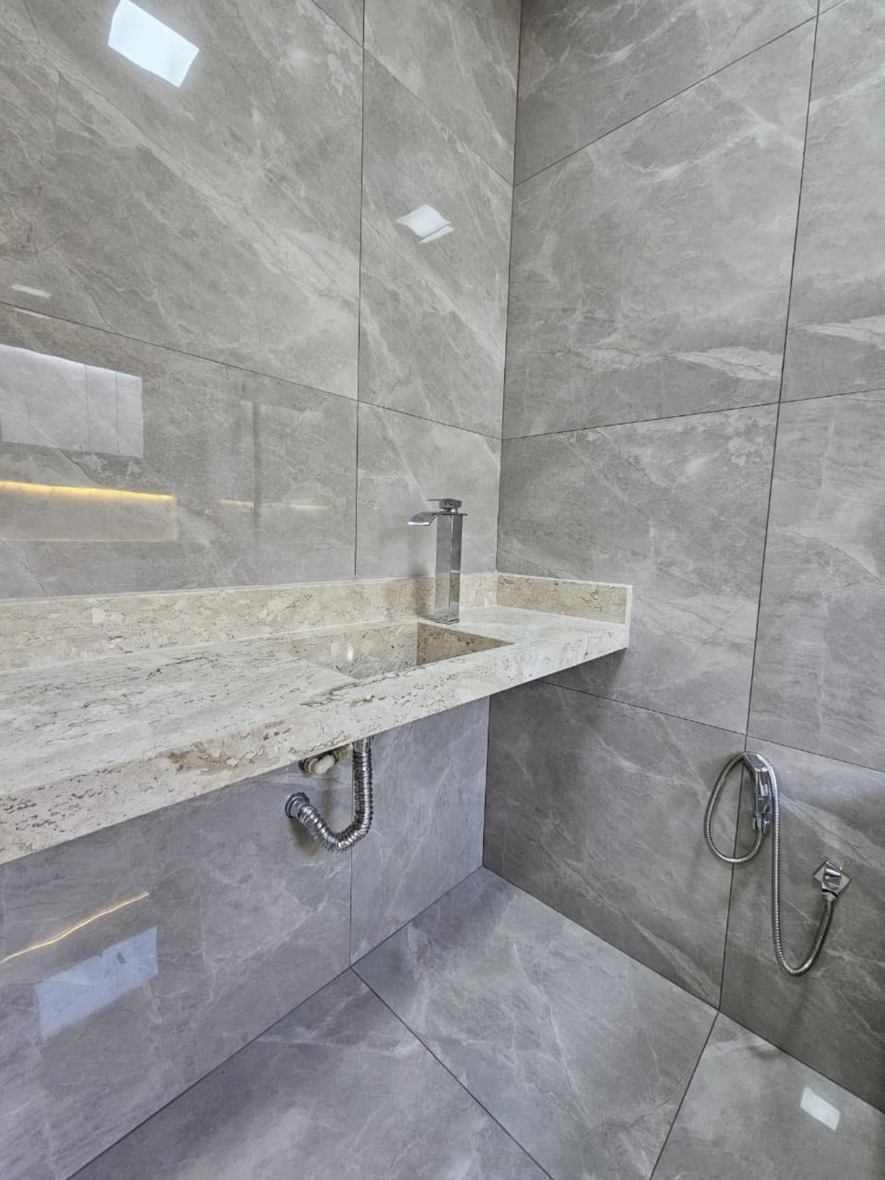 Banheiro social revestido em porcelanato marmorizado