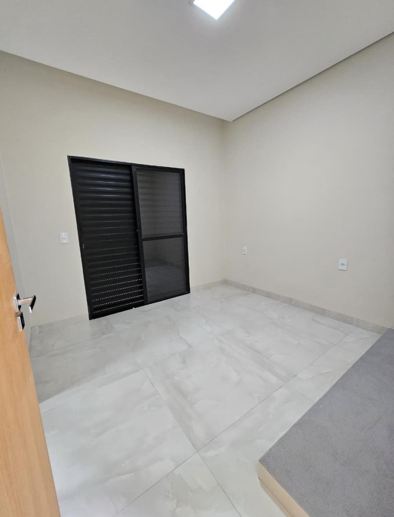 Suíte ampla com porta de vidro e acabamento claro
