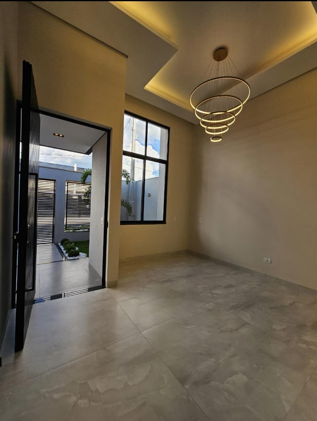 Sala de estar com pé-direito alto e lustre de anéis