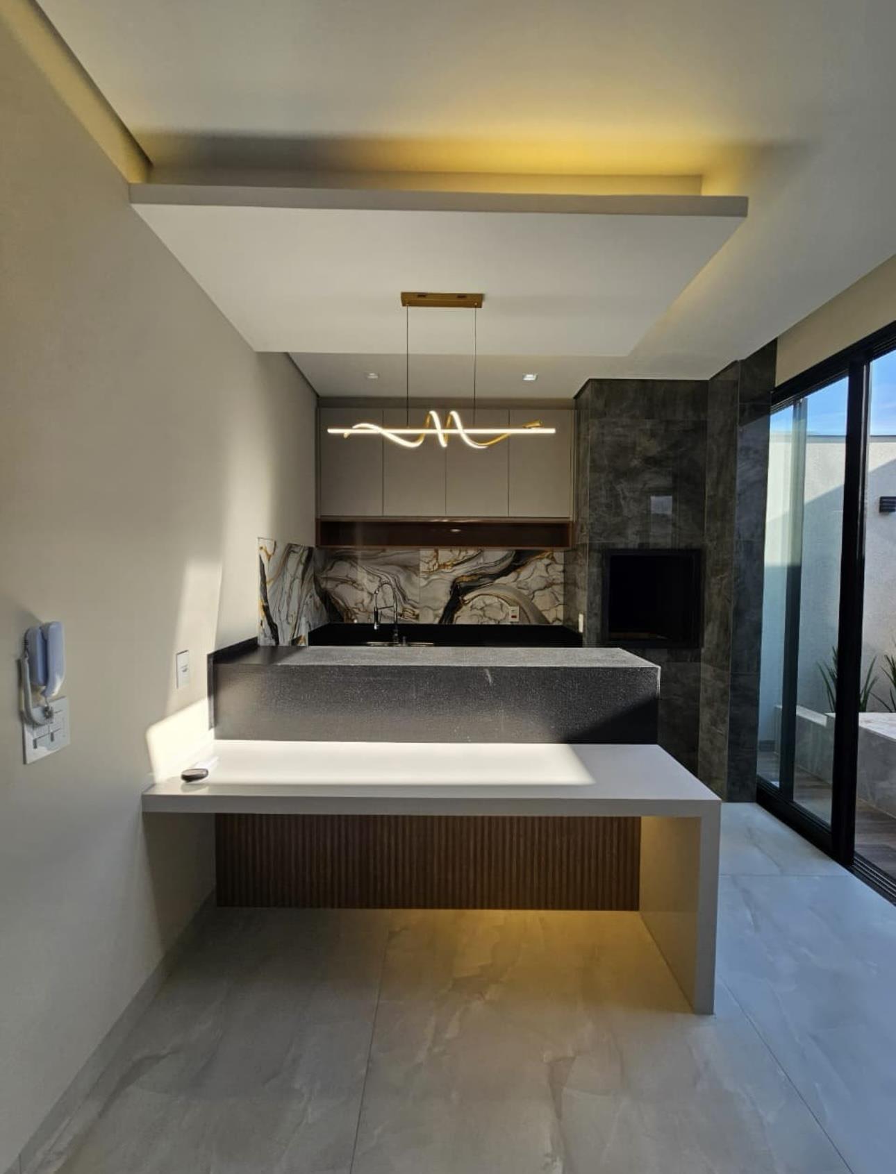 Espaço gourmet com bancada suspensa e vista para a piscina